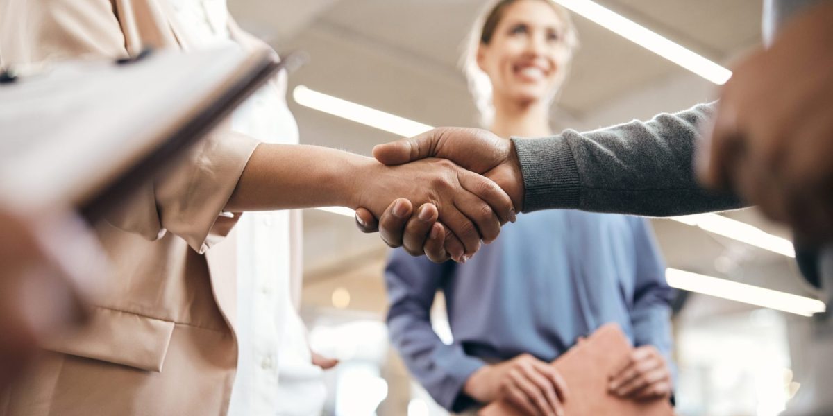 close up of business partners handshaking after successful agreement in office.